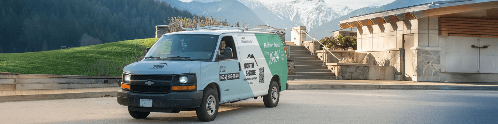 North Shore Plumbing & Heating service van parked with the North Shore Mountains in the background.