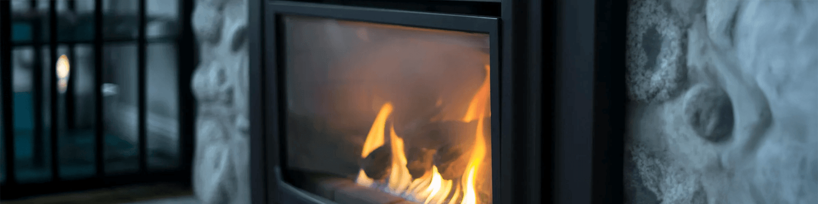 Modern gas fireplace burning in a stone surround inside a North Shore home.